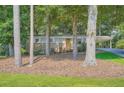 Single-story home with brick facade and covered parking nestled among mature trees at 8767 N View Dr, Lithia Springs, GA 30122