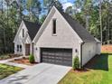 Attractive new home with light brick, a two-car garage and recently planted landscaping at 2335 Azalea Dr, Loganville, GA 30052