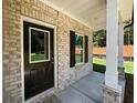 Inviting front porch features a brick facade, white columns, and a stylish front door with a window at 45 Heyman Dr, Covington, GA 30016