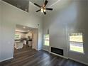 Open-concept living room with high ceilings, wood floors, fireplace, and abundant natural light from large windows at 45 Heyman Dr, Covington, GA 30016