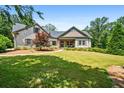 Charming stone-accented home featuring a well-manicured lawn, lovely landscaping, and a welcoming covered porch at 150 Seals Rd, Dallas, GA 30157