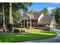 Brick home with a long driveway, mature trees, and lush green grass at 402 Clyde Ct, Mcdonough, GA 30252