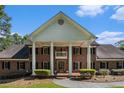 Traditional red brick home featuring white columns and neatly trimmed landscaping at 402 Clyde Ct, Mcdonough, GA 30252