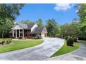 Brick home with a long driveway and mature landscaping in a peaceful, wooded setting at 402 Clyde Ct, Mcdonough, GA 30252