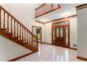 Elegant foyer featuring a staircase, tile flooring, and a decorative wooden front door at 402 Clyde Ct, Mcdonough, GA 30252