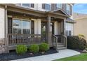Inviting front porch with stone accents, decorative shrubs and charming railings and supports at 5240 Bristlecone Pine Way, Cumming, GA 30040