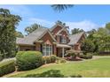 Brick home featuring a well-maintained lawn, professional landscaping, and mature shade trees at 6255 Hedgestone Way, Douglasville, GA 30135