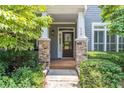 Inviting front door with stone accents, sidelights and decorative glass provides a warm welcome at 510 Independence Way, Roswell, GA 30075