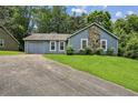 Inviting single-story home with an attached garage, classic siding, and a neatly manicured lawn at 1050 Chapman Circle Cir, Stone Mountain, GA 30088