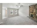 Open living room featuring plush carpeting, a cozy fireplace, and ample natural light from large windows at 1050 Chapman Circle Cir, Stone Mountain, GA 30088