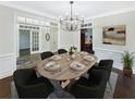 Elegant dining room with modern chandelier, wood floors, and seating for six at 1525 Lake Dow Rd, Mcdonough, GA 30252