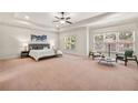 Spacious main bedroom with tray ceilings, ample natural light, and a cozy seating area at 2317 Whiting Bay Courts Nw, Kennesaw, GA 30152