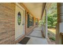 Covered front porch with brick columns, and a decorative oval window on the door at 502 Brookline Pl, Mcdonough, GA 30252