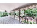 Relax on this covered porch with white railing and a view of the lush surroundings at 203 Cedar Creek Ct, Acworth, GA 30101