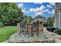 Outdoor kitchen features a stone bar and seating, perfect for enjoying the backyard view at 8455 Abingdon Ln, Duluth, GA 30097