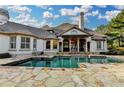 Beautiful pool with stone surround and covered patio, perfect for outdoor relaxation and entertainment at 8455 Abingdon Ln, Duluth, GA 30097