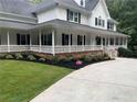 Charming home showcasing a large wraparound porch, black shutters, and fresh landscaping at 125 Sir Lancelot Ct, Fayetteville, GA 30214
