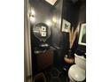 Stylish powder room boasting black walls, gold accents, and modern fixtures at 125 Sir Lancelot Ct, Fayetteville, GA 30214