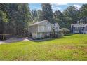 Two-story home with gray siding, a covered front porch, and a driveway leading to an attached garage at 3860 Paint Cir, Douglasville, GA 30135