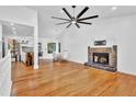 Spacious living room featuring hardwood floors, a stone fireplace, high ceilings, and a modern ceiling fan at 3860 Paint Cir, Douglasville, GA 30135