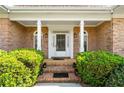 Elegant brick home entrance featuring decorative columns and arched windows flanking the front door at 2012 Arbor Springs Way, Buford, GA 30519