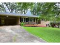 Brick home with a carport and well-manicured front lawn creates an inviting curb appeal at 4852 Pine Shadows Dr, Stone Mountain, GA 30088