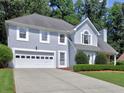 Well-maintained two-story home with an attached garage and beautifully landscaped front yard at 750 Whitehall Way, Roswell, GA 30076