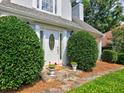 Elegant front entrance with stone walkway, manicured bushes, and decorative flower pots at 750 Whitehall Way, Roswell, GA 30076