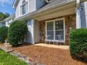 Cozy covered porch features stone accents and seating, perfect for relaxing outdoors at 750 Whitehall Way, Roswell, GA 30076