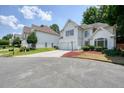 Inviting stucco house featuring a two-car garage, street view, and attractive landscaping at 1971 Wellesley Trce, Dunwoody, GA 30338