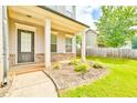 Welcoming covered porch with stately columns, brick accents, and a well-manicured front yard at 2102 Black Pebble Cir, Buford, GA 30519