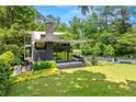 Modern architectural home with expansive lawn, sleek black trim, and thoughtful landscaping at 3891 Wieuca Rd, Atlanta, GA 30342