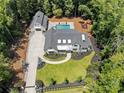 Aerial view showcasing a home with pool, playground, detached garage, four-car garage and lush landscaping at 504 Trinity Church Rd, Canton, GA 30115