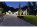 Well-lit home with a long driveway leading to a detached garage and attached four-car garage at 504 Trinity Church Rd, Canton, GA 30115