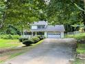 Charming two-story home with a front porch, attached garage and well-manicured landscaping at 460 Heathrow Way, Stone Mountain, GA 30087