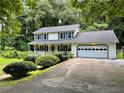 Charming two-story home with a front porch, attached garage and well-manicured landscaping at 460 Heathrow Way, Stone Mountain, GA 30087