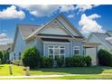 Quaint blue home with mature landscaping, a well-manicured lawn, and a covered entryway at 903 Duncan Ter, Canton, GA 30115