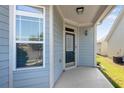 Covered front porch featuring blue siding, a storm door, and ample natural light through the window at 903 Duncan Ter, Canton, GA 30115