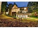Exterior view of the house with a deck, patio, and backyard surrounded by mature trees at 1595 Northcliff Trce, Roswell, GA 30076