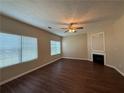 Bright living room featuring wood floors, a ceiling fan, and a modern fireplace at 425 Bell Flower Trl, Locust Grove, GA 30248
