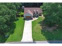 Aerial shot shows the home on a landscaped lot with mature trees, long driveway, and private backyard at 106 Kimbell Farm Dr, Locust Grove, GA 30248