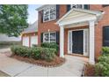 Close up of a red brick home showcasing a two-car garage and charming front entrance at 2683 Berry Ridge Ct, Buford, GA 30519