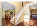 Bright foyer featuring hardwood floors, a staircase with white railings, and views into the dining and living rooms at 3053 Ramsey Pl, Marietta, GA 30062