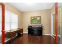 Cozy office space with dark hardwood floors, a large desk, and a piano, perfect for a home workspace at 3053 Ramsey Pl, Marietta, GA 30062