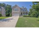 Attractive brick home with a welcoming front porch, neat landscaping, and a long driveway at 4445 Hager Ct, Cumming, GA 30040