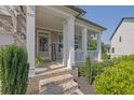 Inviting front porch with classic white columns and brick accents, creating a warm entrance at 4445 Hager Ct, Cumming, GA 30040