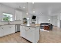 Open-concept kitchen with granite island, stainless appliances, and view of the living room at 5985 Hidden Ridge Ct, Cumming, GA 30028