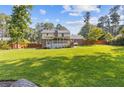 Spacious backyard featuring a well-maintained lawn, wooden fence and a covered deck at 425 Houze Way, Roswell, GA 30076