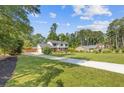 Long driveway leading up to a well-kept two-story home with mature trees and expansive lawn at 425 Houze Way, Roswell, GA 30076