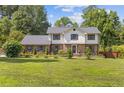 Attractive two-story home with a brick and white exterior, complemented by a large, green front lawn at 425 Houze Way, Roswell, GA 30076